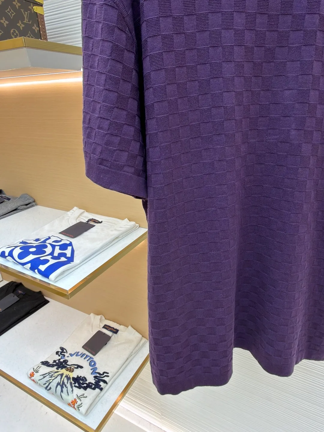 LOUIS VUITTON letter embroidered dark checkerboard jacquard short sleeves ●Original version: Purchased and developed at 9350 ●Item number: 1682319-B00 ●Fabric: 100% cotton ●Technology: jacquard knitting ●Color: Purple ●Version: Fitted version ●Weight: about 340 grams ●Size: S-M-L-XL ●Description: This Louis Vuitton purple knitted short-sleeve is made of custom worsted wool blended fabric. It is created with an 18-needle high-density weaving process using a computerized flat knitting machine to create a three-dimensional checkerboard texture. The checkered pattern is laser positioned and patterned. The size and spacing of each grid are accurate to 0.1 cm, showing a regular relief texture. The left chest uses same-color inlay embroidery technology, and the "LVM SINCE 1854" logo is embroidered with a high density of 1200 stitches/square centimeter. The embroidery thread is made of high-elastic mercerized cotton thread of the same color as the body, forming a natural texture layer with the knitted base. The neckline adopts seamless cylindrical rib technology, which is not easy to loose after high-temperature shaping treatment. The shoulders are made of seamless bonding technology to reduce the abruptness of the seams. The overall micro-profile tailoring combined with the invisible stitching technology of the side seams not only ensures the comfort of wearing, but also makes the body lines smoother. Each process has undergone multiple quality control tests by the brand to ensure the quality and durability of the craftsmanship. The overall wiring is straight and delicate, the fabric is comfortable and soft, and the color is consistent without color difference. It can be matched with the same style to create a fashionable look and control various occasions. Customized accessories, complete with three standards, same style for men and women!